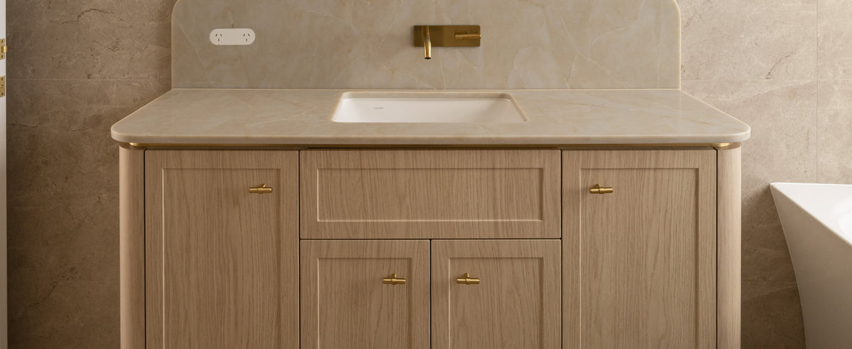 Brass T-knobs on the cupboard doors of an oak bathroom vanity