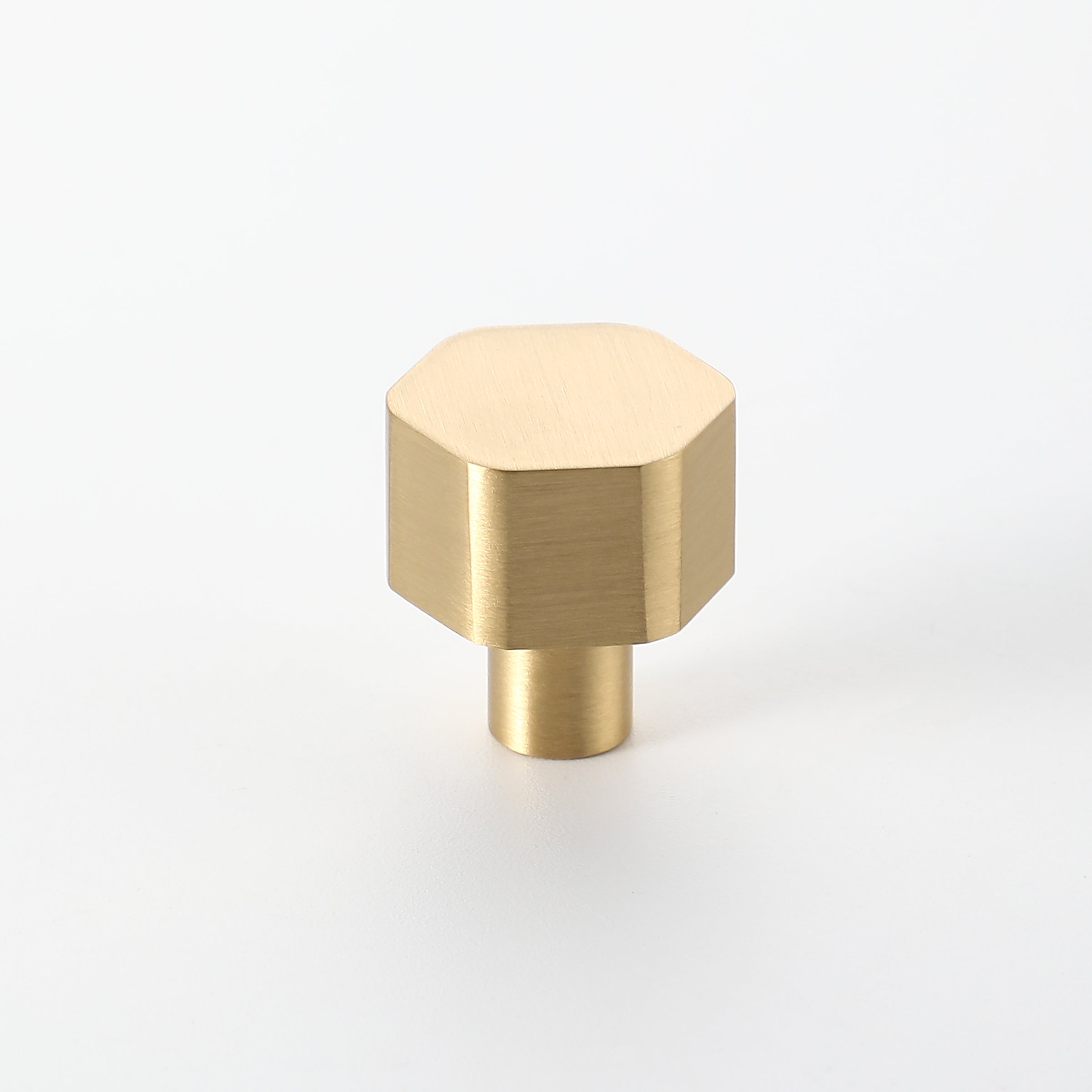Hexon brass knob in brushed brass finish with geometric hexagon design.
