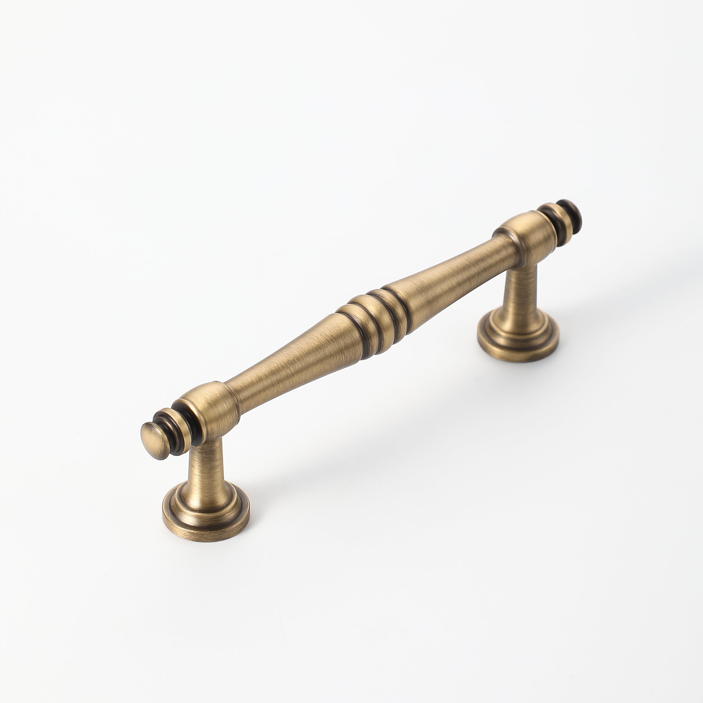 Vintage brass cabinet handle with elegant spindle design.