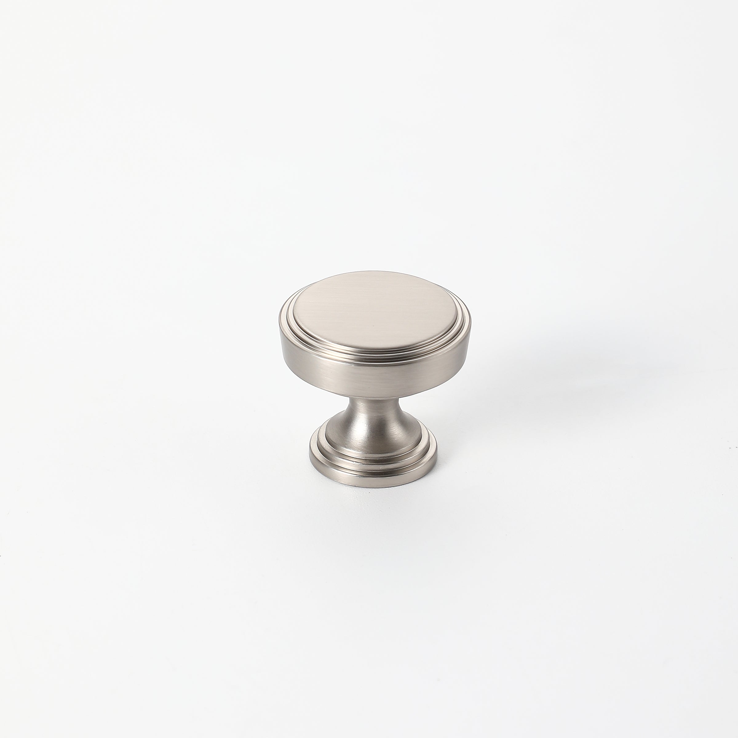 Brushed nickel drawer knob with a smooth, elegant finish, ideal for modern cabinet designs.
