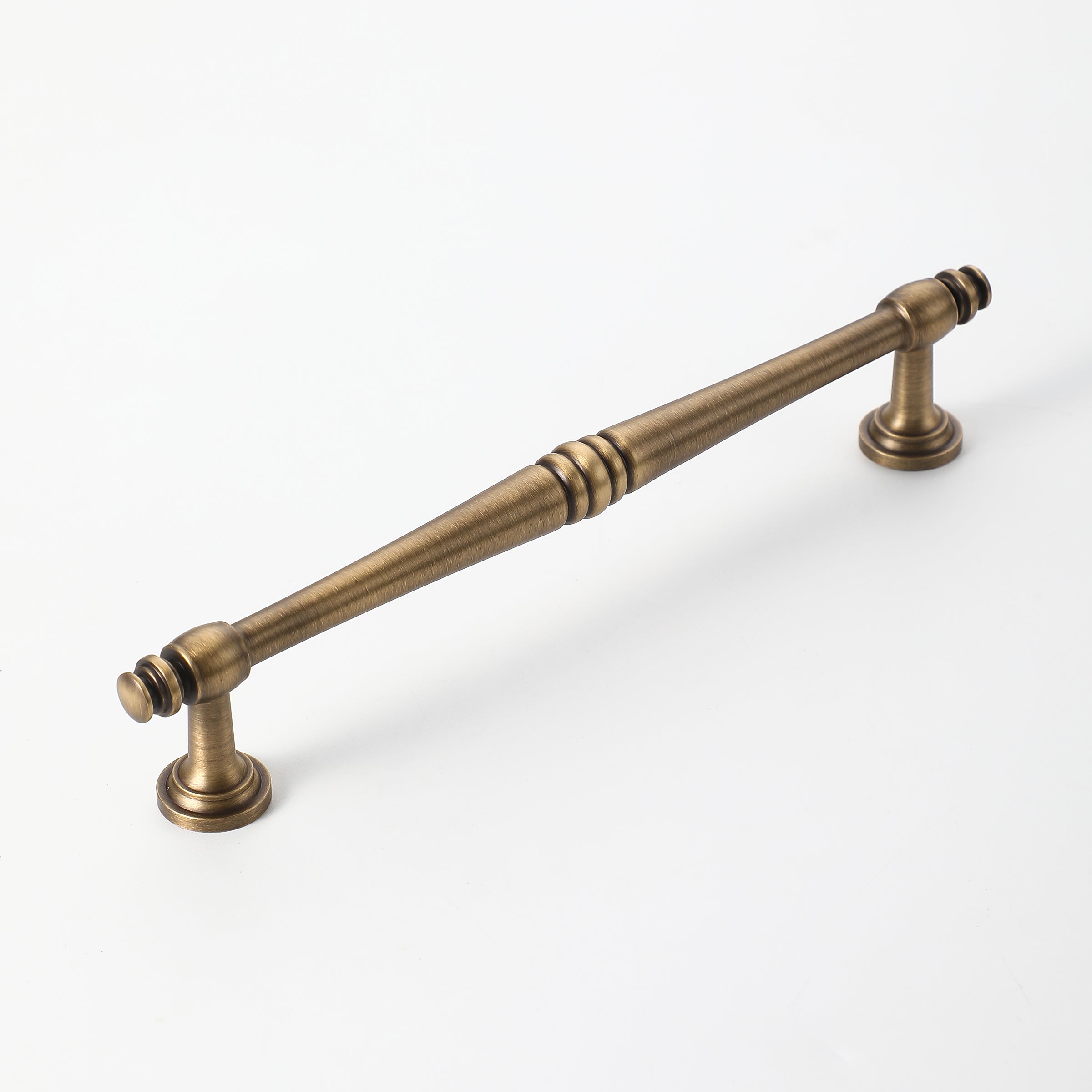 Long antique brass cabinet handle with detailed design and smooth finish.