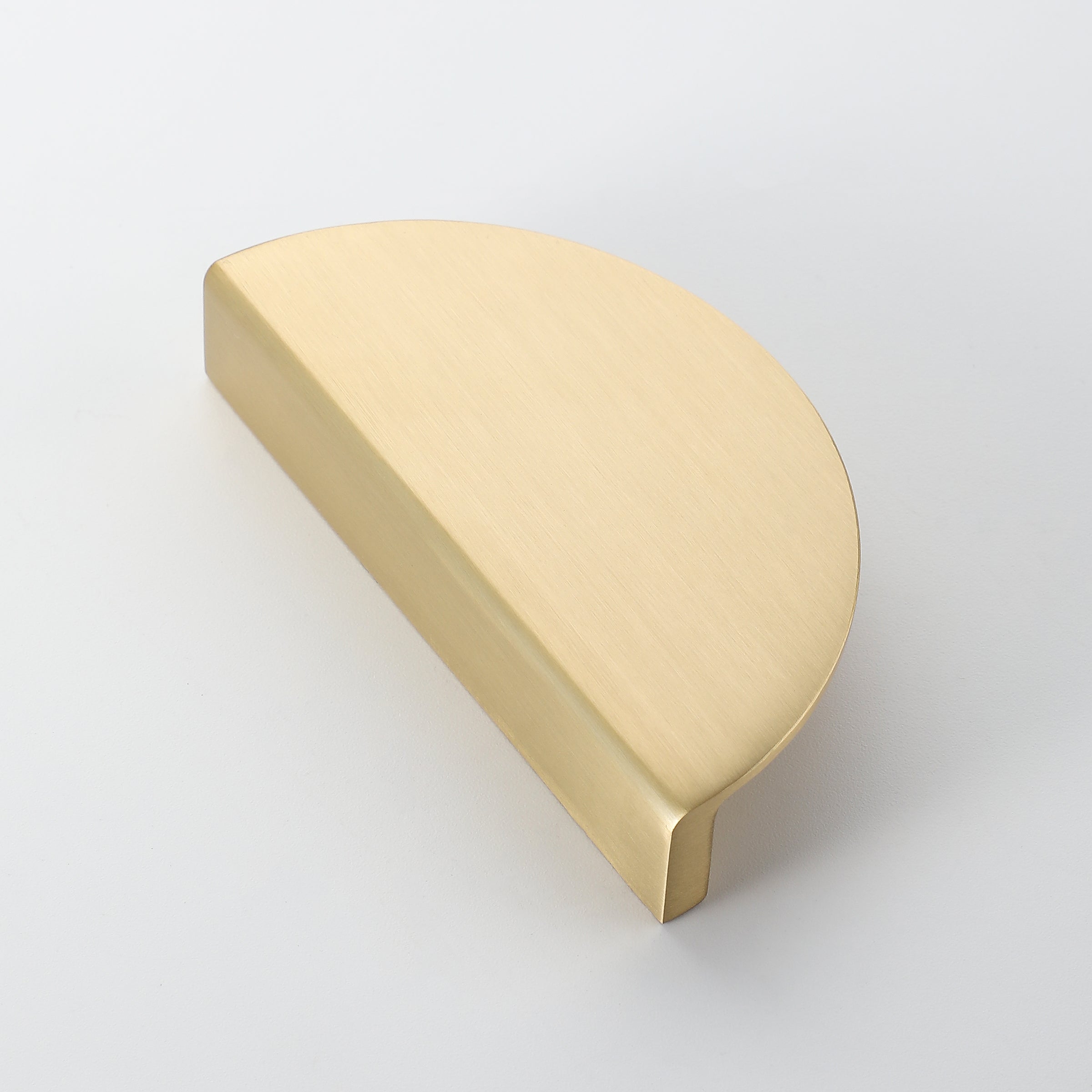 Half moon dresser handle in brushed brass finish, shown from angle view to highlight surface texture.
