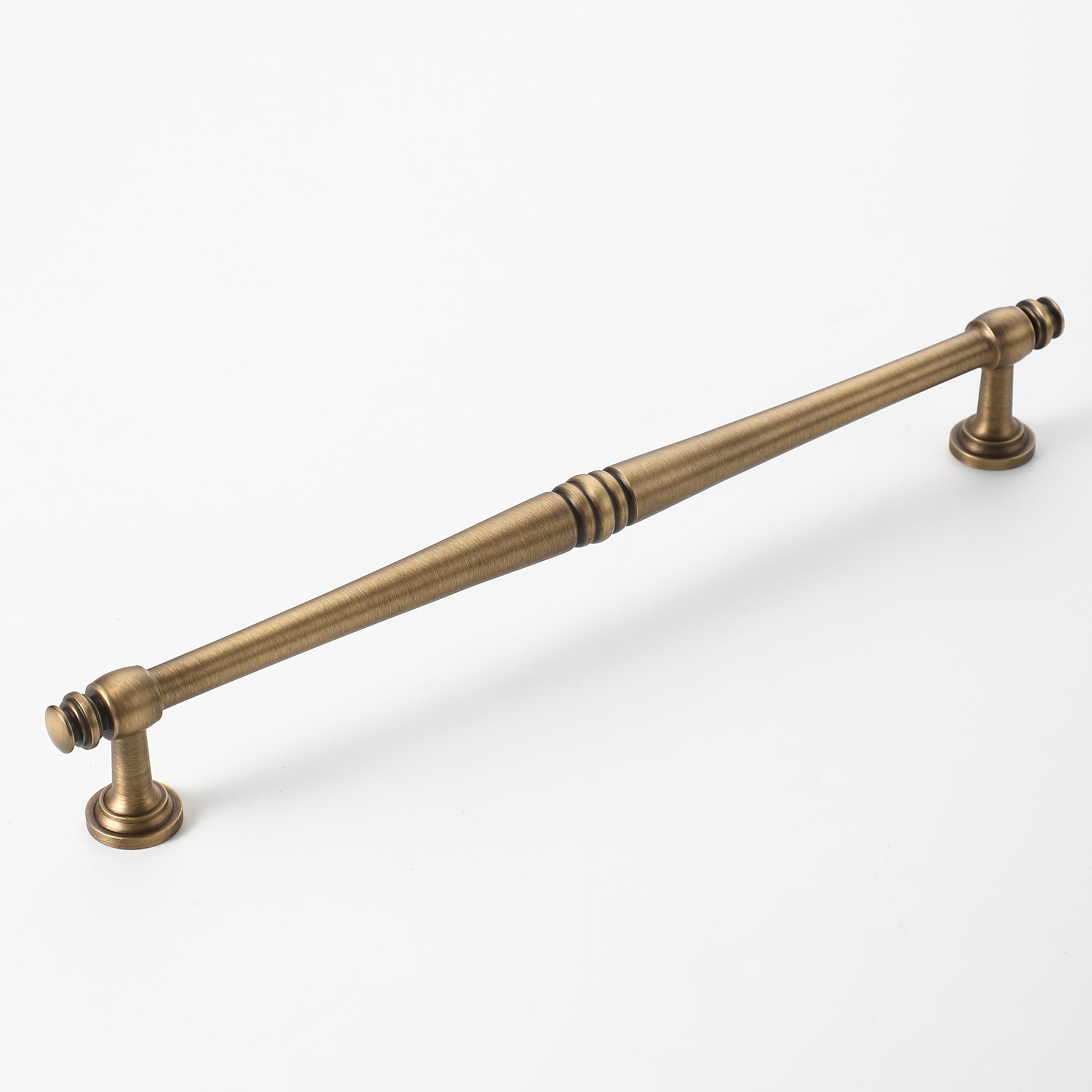 Antique brass cabinet pull handle with timeless spindle detailing.