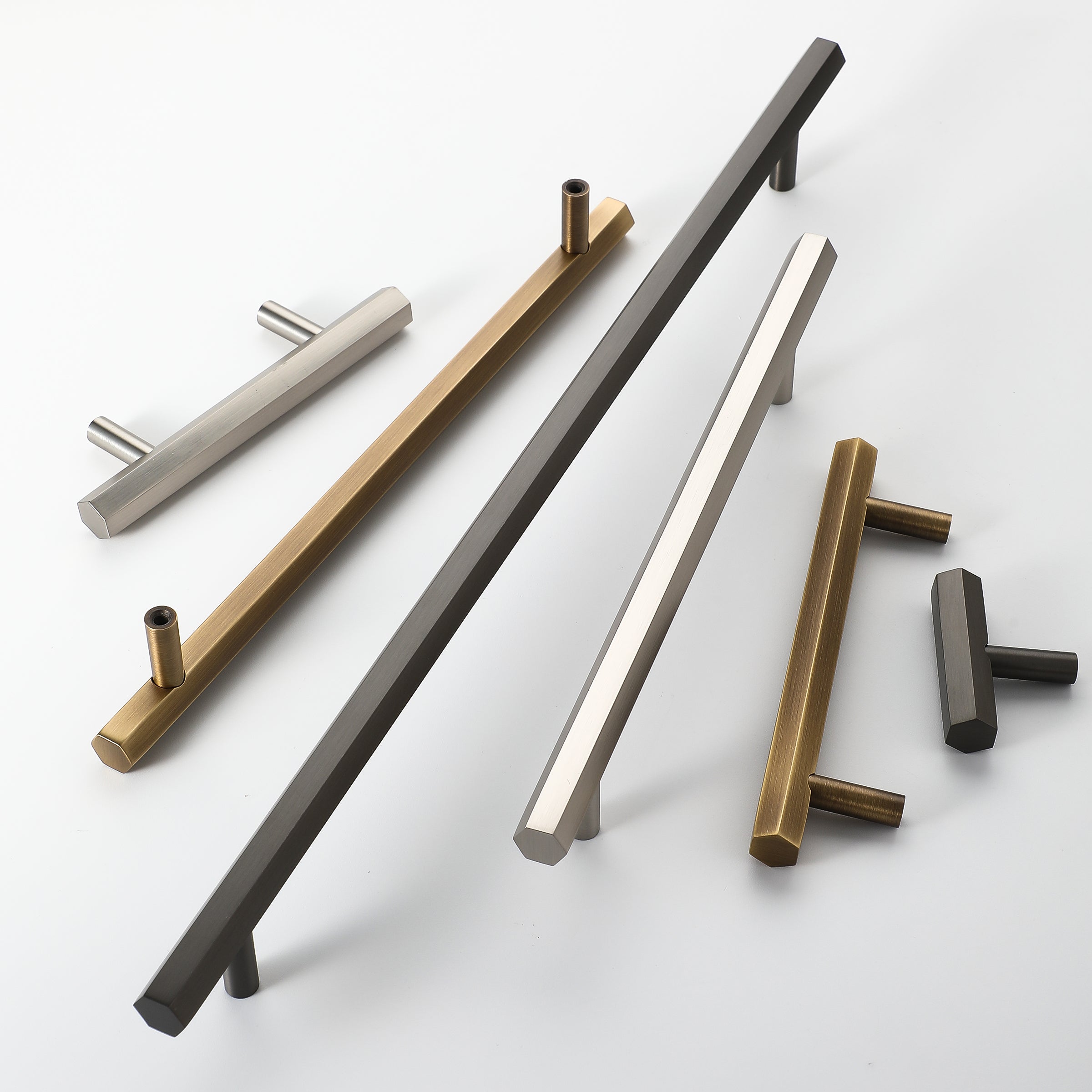 Five Geo hexagonal bar pulls and a Geo T-knob in antique brass, gunmetal and brushed nickel
