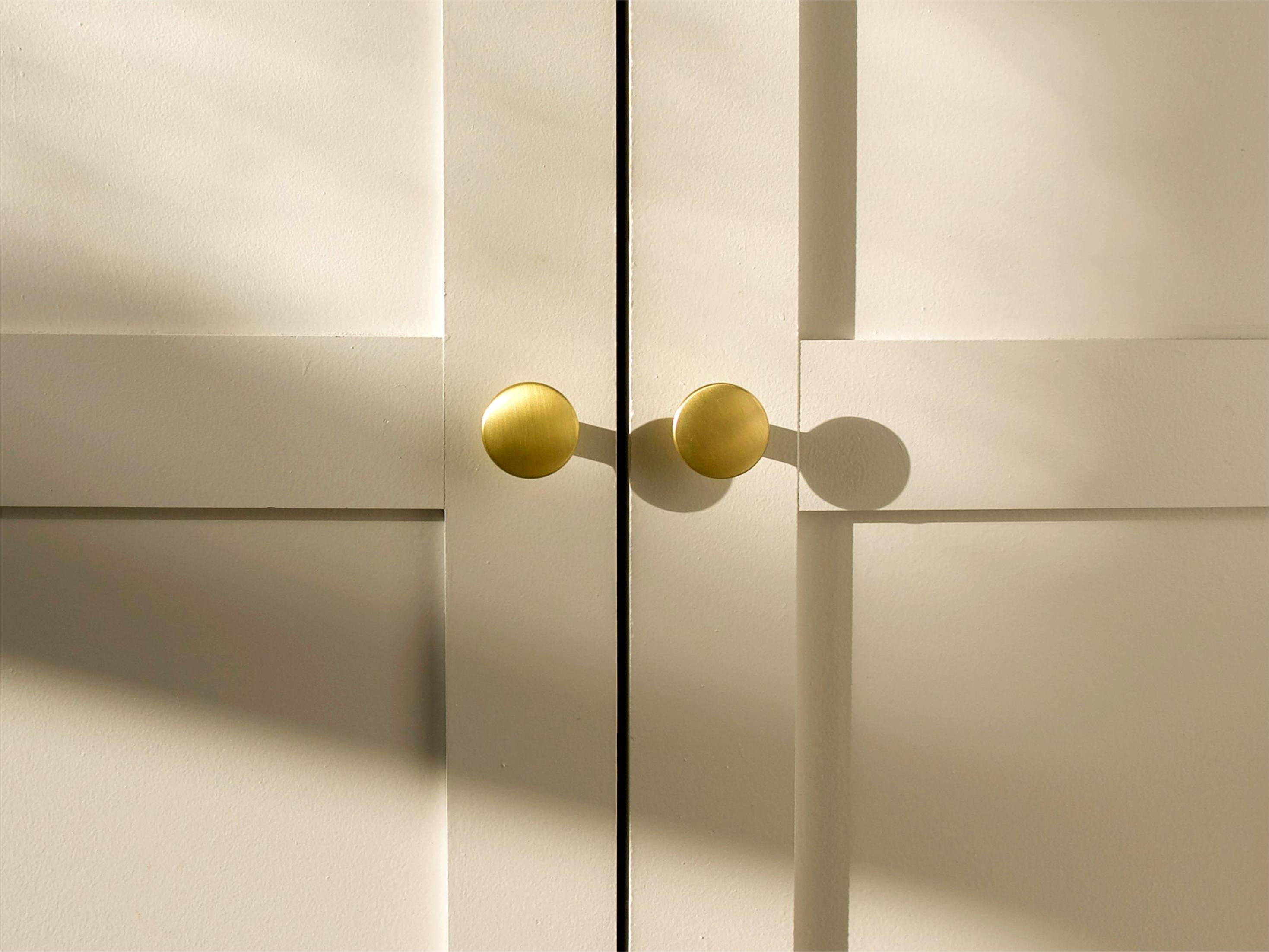 brass door handles on the light-colored cabinet doors