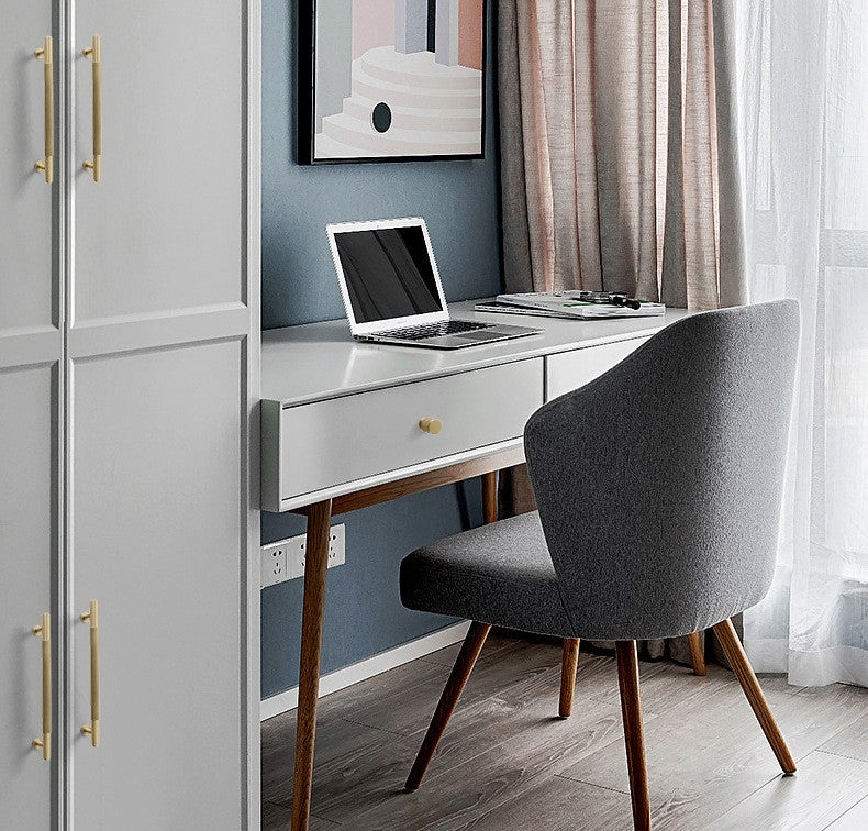 White cabinet with brass door knobs and handles in a modern home office setup