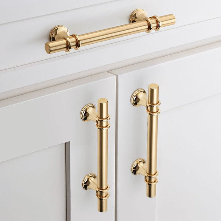 Brass cabinet handles on a white cabinet featuring